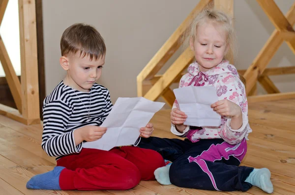 Liten pojke och flicka sitter tillsammans läser — Stockfoto