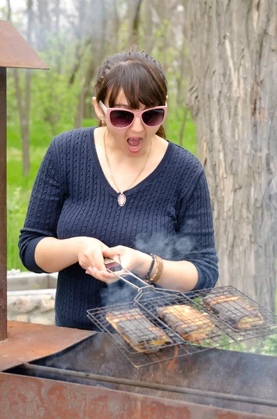 Donna che cucina su un barbecue reagendo con orrore — Foto Stock
