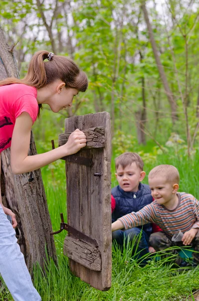 Tienermeisje kijken naar twee jongens spelen — Stockfoto