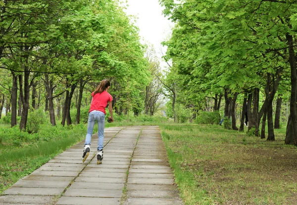 Athletic tonårsflicka rullskridskoåkning i en park — Stockfoto