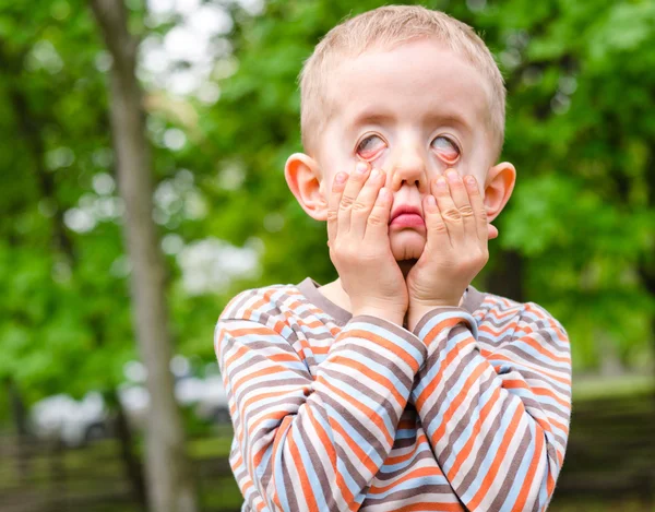 Liten pojke dra ett skrämmande uttryck — Stockfoto