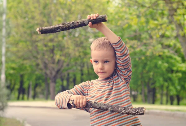 Little boy playing with fighting sticks — Stock Photo, Image