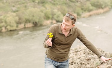 Man looking at fresh yellow wildflowers clipart