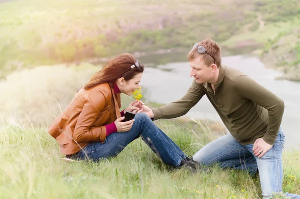 Giovane uomo che offre fiori gialli a una ragazza — Foto Stock