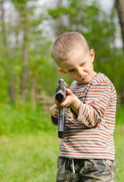 Schattige jongen gericht met machine gun — Stockfoto