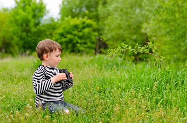 Mladý kluk hraje s dalekohledem — Stock fotografie