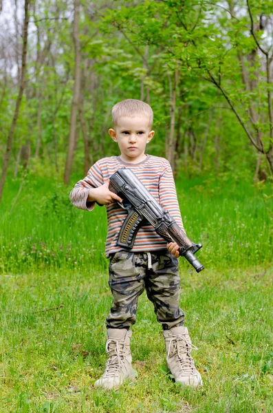 Jonge jongen poseren met machine gun — Stockfoto