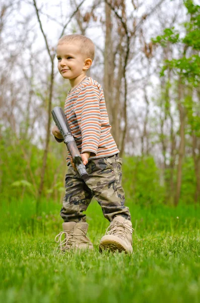 Jonge jongen poseren met machine gun — Stockfoto