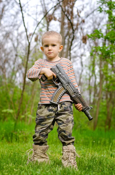 Jonge jongen poseren met machine gun — Stockfoto