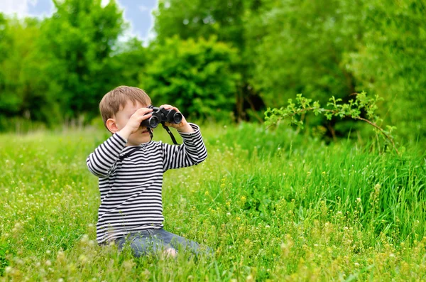 Mladý kluk hraje s dalekohledem — Stock fotografie