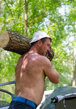 Ahşap büyük bir günlük taşıyan güçlü kas adam