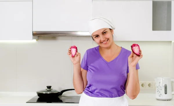 Lächelnder Koch hält eine in Scheiben geschnittene rote Zwiebel hoch — Stockfoto
