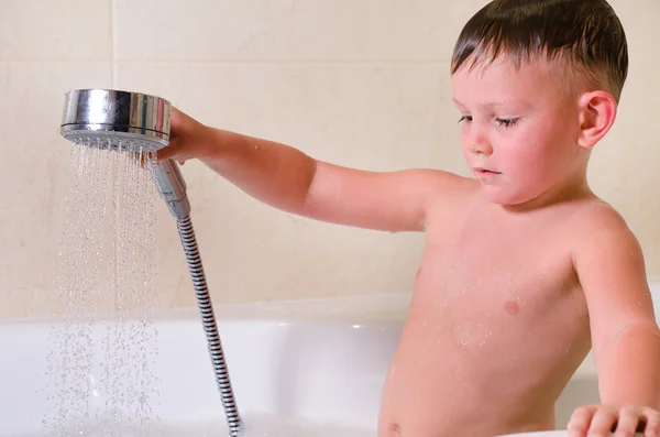 Chłopiec trzyma prysznic nad głową — Zdjęcie stockowe