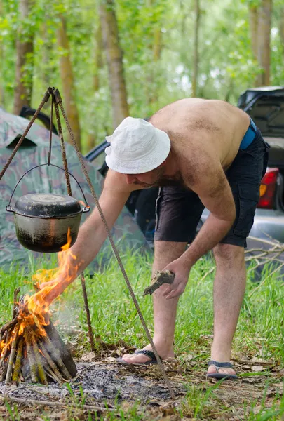 Человек зажигает костер во время похода — стоковое фото