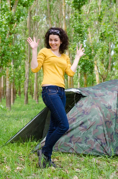 Gelukkig jonge vrouw poseren voor een tent — Stockfoto