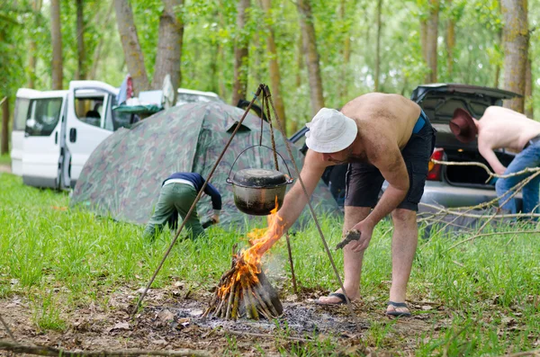 Man lighting a cooking fire while camping — Stock Photo, Image
