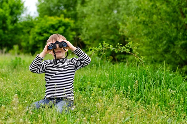 Kleine jongen op zoek naar de camera met verrekijkers — Stockfoto