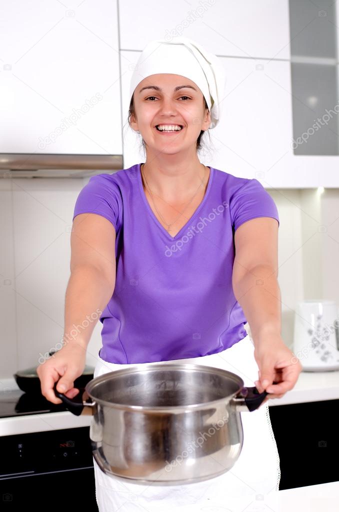 Laughing attractive cook with a big pot