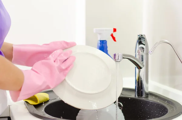 Frau spült Teller unter den Wasserhahn — Stockfoto