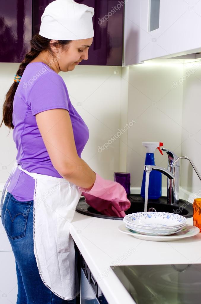 Smiling woman cook cleaning dishes