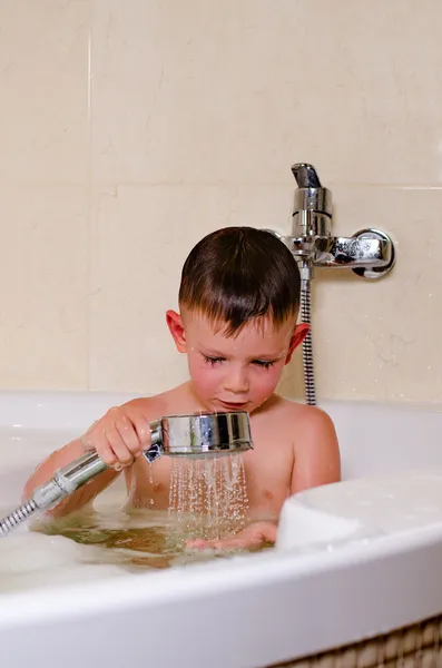Schattige kleine jongen douchen in het bad — Stockfoto