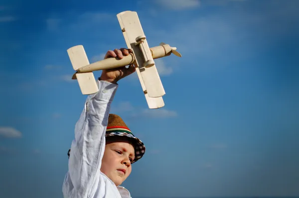 可爱的小男孩，他的玩具双翼飞机飞行 — 图库照片