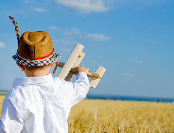 Carino piccolo ragazzo volare il suo giocattolo biplano — Foto Stock