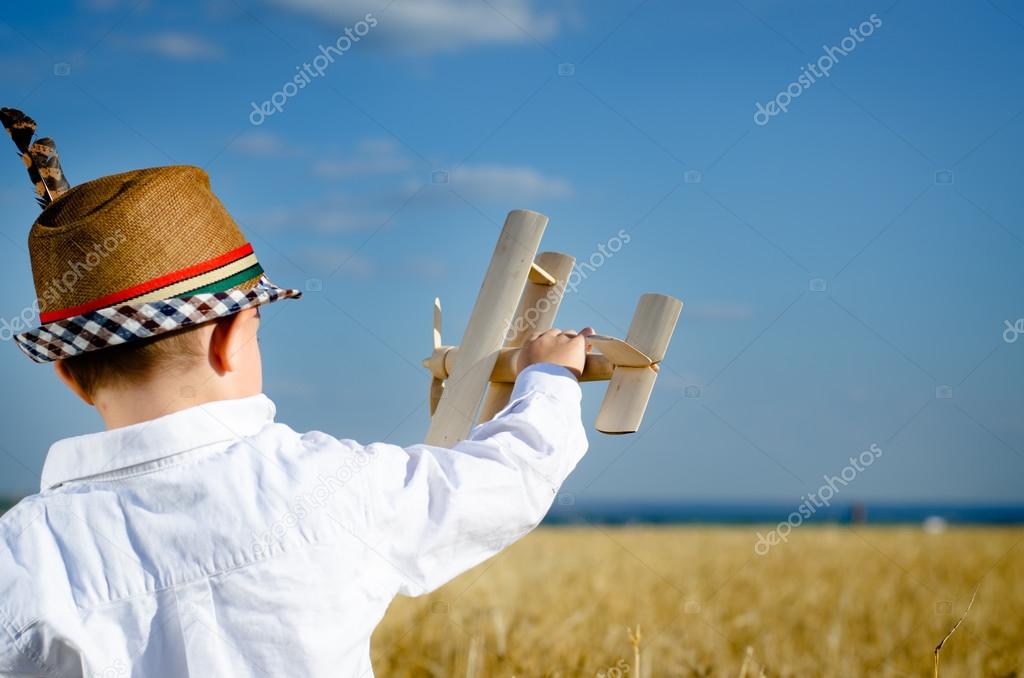 Little boy in a cute hat playing with an airplane