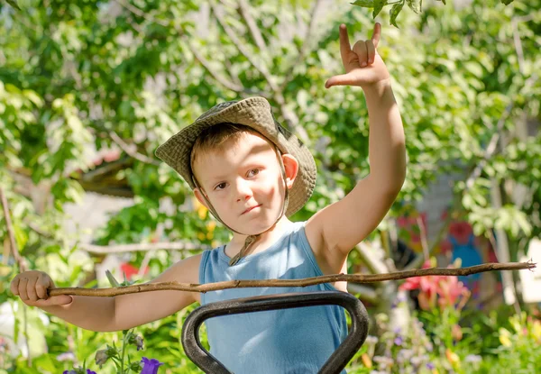 Ung pojke leker med en pinne och gester — Stockfoto