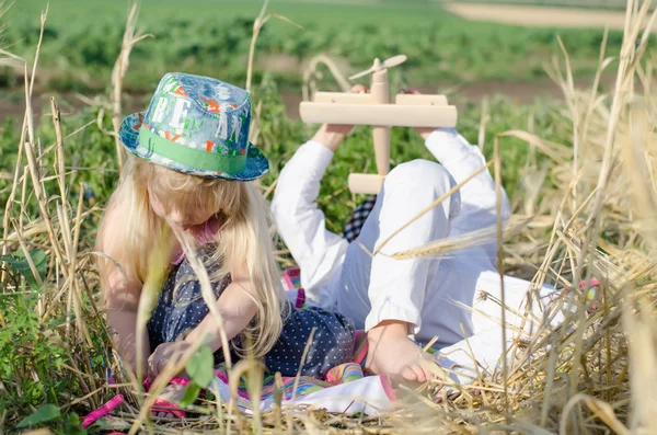 Niño y niña jugando en un campo de trigo — Foto de Stock