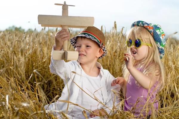 Duas crianças pequenas brincando com um avião modelo — Fotografia de Stock