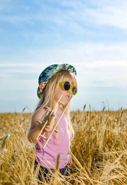 Söt liten flicka i en färgglad hatt och solglasögon — Stockfoto