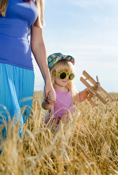 Klein meisje lopen in een tarweveld met moeder — Stockfoto