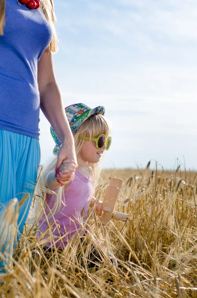 Niña caminando en un campo de trigo con madre —  Fotos de Stock