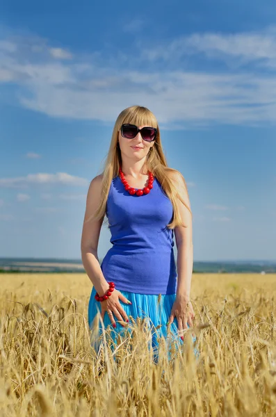 Mulher de pé desfrutando do sol em um campo de trigo — Fotografia de Stock