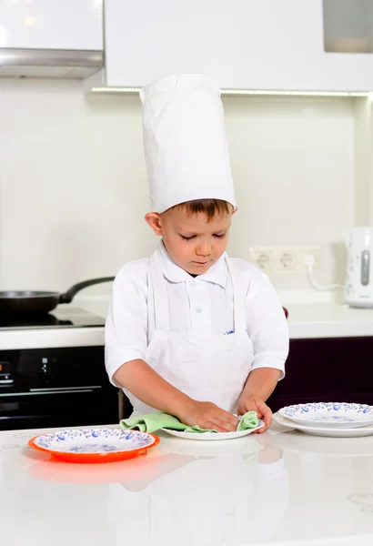 Cute young chef checking his dinner plates — Stock Photo, Image