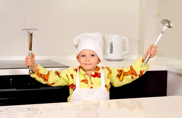 Schattige jongen chef-kok zijn gebruiksvoorwerpen weergeven — Stockfoto