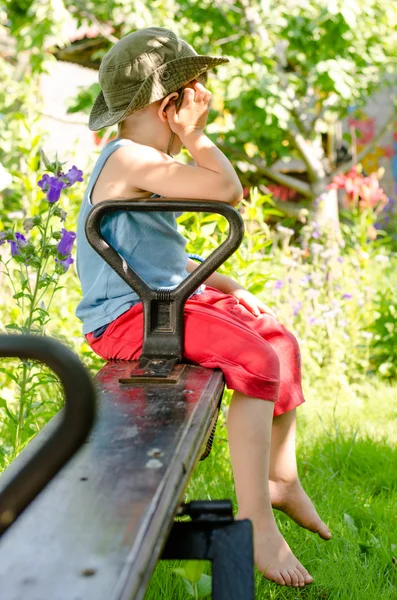 Kleine jongen mokkend als hij zit op een wip — Stockfoto