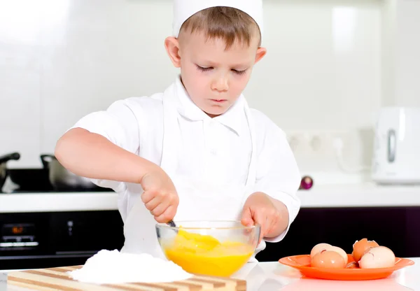 Jonge jongen bakken zweepslagen eieren — Stockfoto