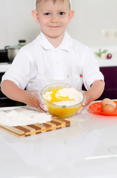 Lindo chico joven horneando un pastel — Foto de Stock