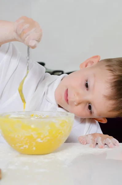 Mignon jeune garçon apprendre à balancer un gâteau — Photo
