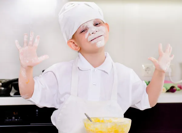 Schattige kleine jongen met zijn gezicht bedekt met bloem — Stockfoto