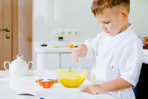 Liten pojke att lära sig baka läsa receptet — Stockfoto