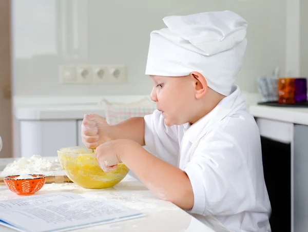 Vrolijk jonge chef-kok bakken in de keuken — Stockfoto