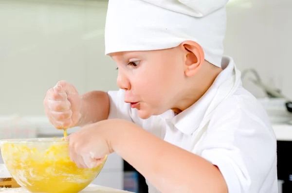 Vrolijk jonge chef-kok bakken in de keuken — Stockfoto