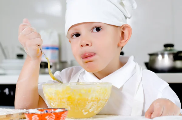 Cute little chef tasting his cooking — Stock Photo, Image