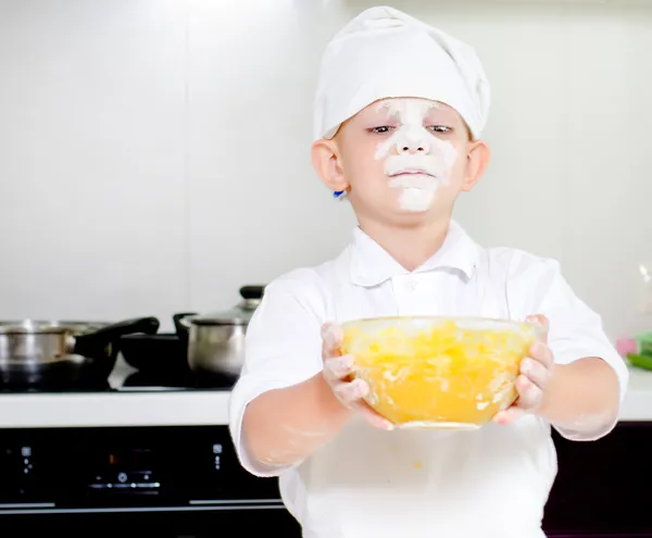 Fier petit garçon chef avec un visage plein de farine — Photo