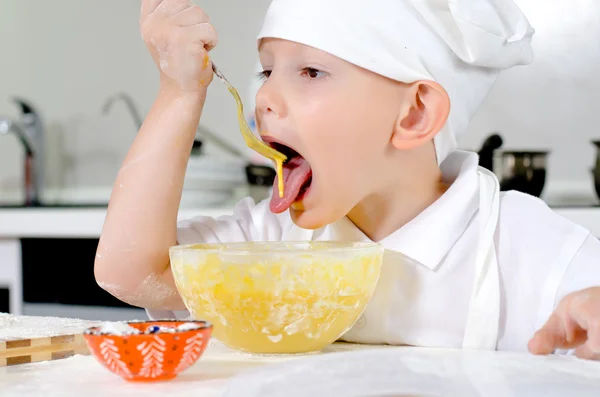 Cute little chef tasting his cooking — Stock Photo, Image