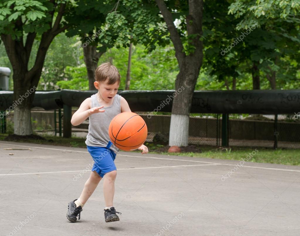 Young boy playing basketball — Stock Photo © ampack 50193889