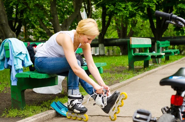 Chica joven quitando sus patines — Foto de Stock